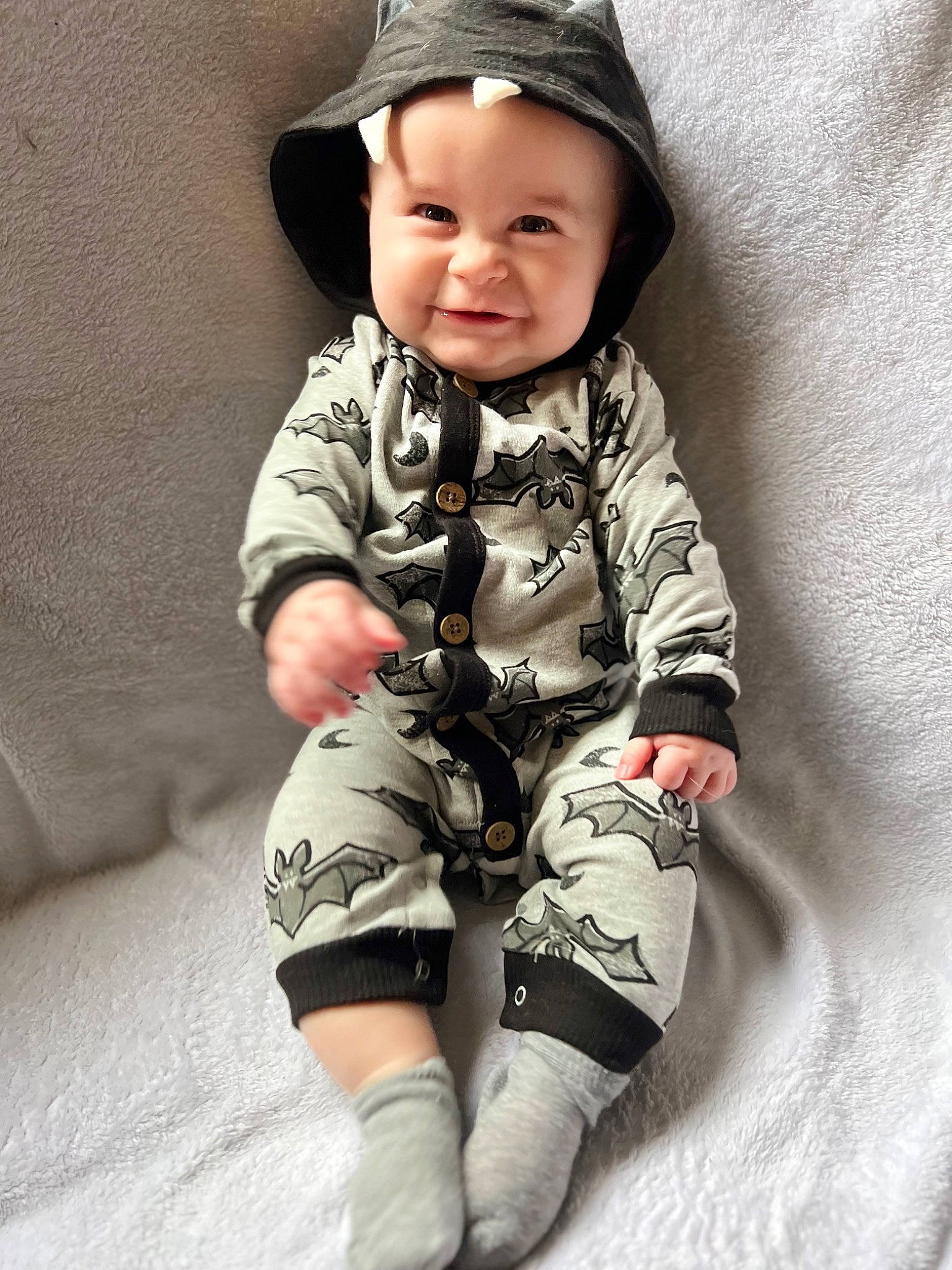 Grayson is registered to the contest to win money with this photo: baby, baby_toddler_clothing, cap, child, collar, comfort, cool, face, fashion_accessory, happy, headwear, human_leg, joy, neck, pattern, person, sitting, skin, sleeve, smile