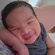 Enoc participe au concours pour gagner de l'argent avec cette photo : baby, smiling, face, arm, hand, pillow, floral_pattern, indoor, sleepy, cute, child, person, skin, resting, infant, portrait, cozy, young, happy, casual