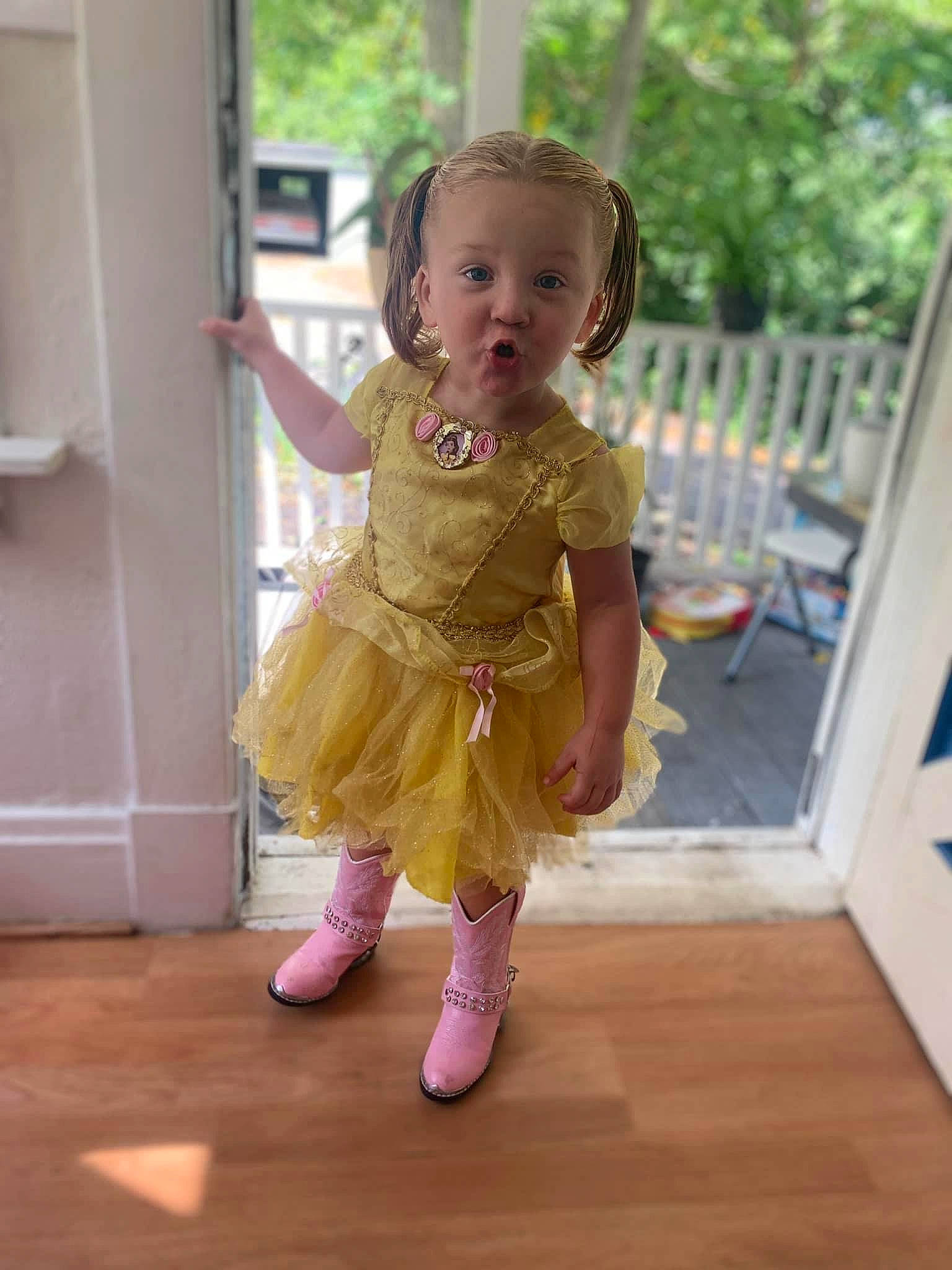 Aryan is registered to the contest to win money with this photo: baby, baby_toddler_clothing, child, event, face, floor, flooring, fun, hair, happy, hardwood, head, human_leg, magenta, person, pink, standing, toddler, tree, wood