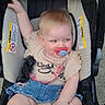 baby, stroller, pacifier, child, denim_skirt, beige_top, sitting, cute, infant, outdoor, safety_straps, happy, smiling, skin, hair, footwear, one_arm_raised, comfort, childcare, playful