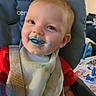 baby, bib, blue_food, child, cute, face, feeding_time, food_stains, happy, high_chair, indoor, messy, playful, portrait, red_shirt, seat, smile, straps, toddler, young_child