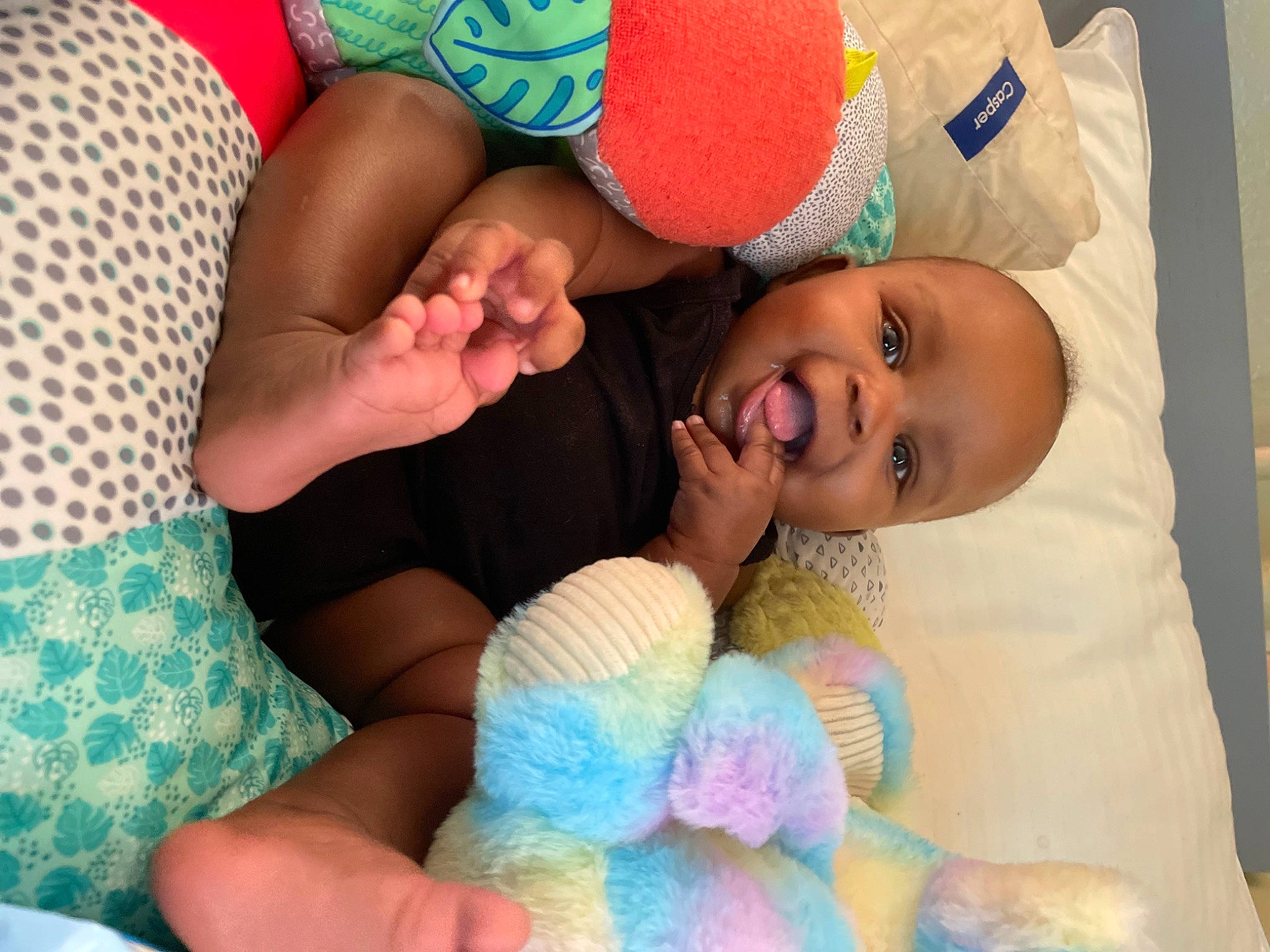 Amya is registered to the contest to win money with this photo: baby, baby_toddler_clothing, blue, child, comfort, event, finger, fun, gesture, hand, happy, human_leg, linens, nail, person, product, skin, smile, textile, thumb