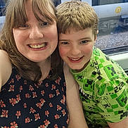 James is registered to the contest to win money with this photo: woman, boy, smiling, portrait, selfie, train, window, clothing, casual, happy, face, people, hair, seat, transport, public_transport, indoor, child, person, travel