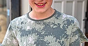 James joined the competition — help win amazing prizes! background_blur, boy, camouflage_shirt, casual, child, daylight, door, face, happy, light, outdoor, person, portrait, short_hair, skin, smiling, standing, wall, winking, young