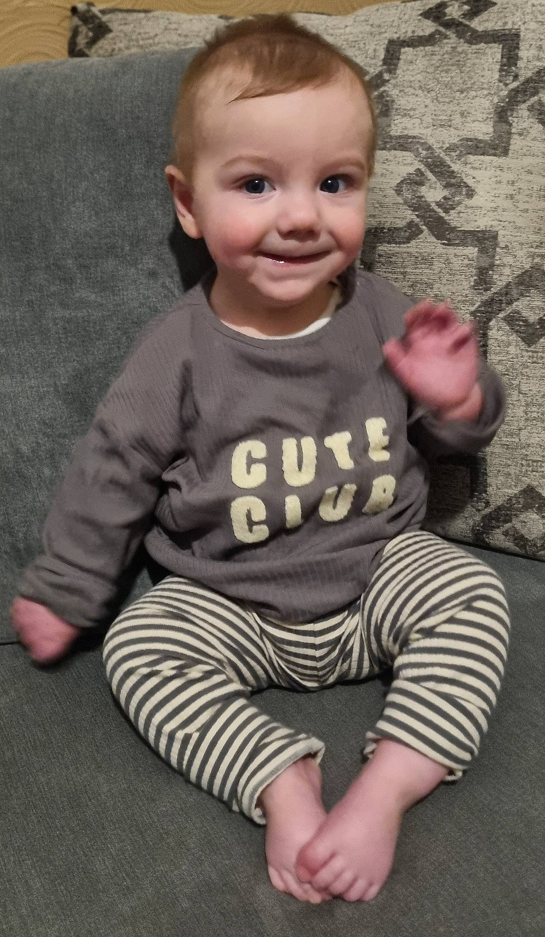 Orlando joined the competition — help win amazing prizes! casual, child, clothing, couch, cozy, cute, face, feet, happy, home, indoor, person, portrait, sitting, smiling, striped_pants, sweater, toddler, waving, young_child