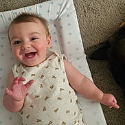 Orlando joined the competition — help win amazing prizes! arm, baby, carpet, changing_pad, child, cute, dog, face, floor, hand, happy, indoor, infant, onesie, pet, resting, smiling, stars, teddy_bear_pattern, toddler