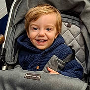 Orlando joined the competition — help win amazing prizes! child, toddler, baby, smiling, happy, portrait, stroller, car_seat, harness, buckled, blue_clothing, hoodie, red_hair, brown_eyes, indoors, close_up, seated, infant, safe, photography