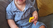 Orlando is registered to the contest to win money with this photo: toddler, child, smiling, blue_eyes, short_hair, blue_shirt, yellow_blocks, couch, gray_cushion, yellow_cushion, indoor, happy, sitting, barefoot, cute, portrait, playful, cozy, home, person