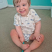 Orlando is registered to the contest to win money with this photo: toddler, child, smiling, sitting, carpet, indoor, toy, cute, animal_print, shirt, shorts, happy, playful, young_child, portrait, blue_wall, floor, barefoot, person, casual