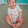 toddler, child, smiling, sitting, carpet, indoor, toy, cute, animal_print, shirt, shorts, happy, playful, young_child, portrait, blue_wall, floor, barefoot, person, casual