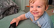 Orlando joined the competition — help win amazing prizes! toddler, child, smiling, toy_car, blue_eyes, short_hair, couch, blanket, indoor, radiator, happy, casual_clothing, playful, home, person, young_child, smile, hand, furniture, relaxation