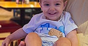 Orlando joined the competition — help win amazing prizes! child, toddler, smile, happy, person, indoor, seated, clothing, shorts, tshirt, feet, hand, face, hair, table, chair, background, blurred, restaurant, cafe