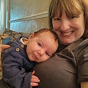 Orlando is registered to the contest to win money with this photo: baby, child, clothing, couch, cozy, face, hair, hand, happy, holding, home, indoor, person, portrait, relax, skin, smile, sweater, together, woman