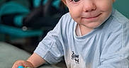 Orlando is registered to the contest to win money with this photo: blue_toy, casual_clothing, child, close_up, couch, eyes, face, furniture, hands, happy, home, indoor, portrait, red_hair, short_hair, sitting, smiling, t_shirt, toddler, toy