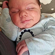 Orlando joined the competition — help win amazing prizes! baby, sleeping, infant, smile, face, hand, clothing, pillow, cloud_pattern, soft_fabric, close_up, resting, newborn, cute, peaceful, indoors, portrait, child, relaxing, cozy