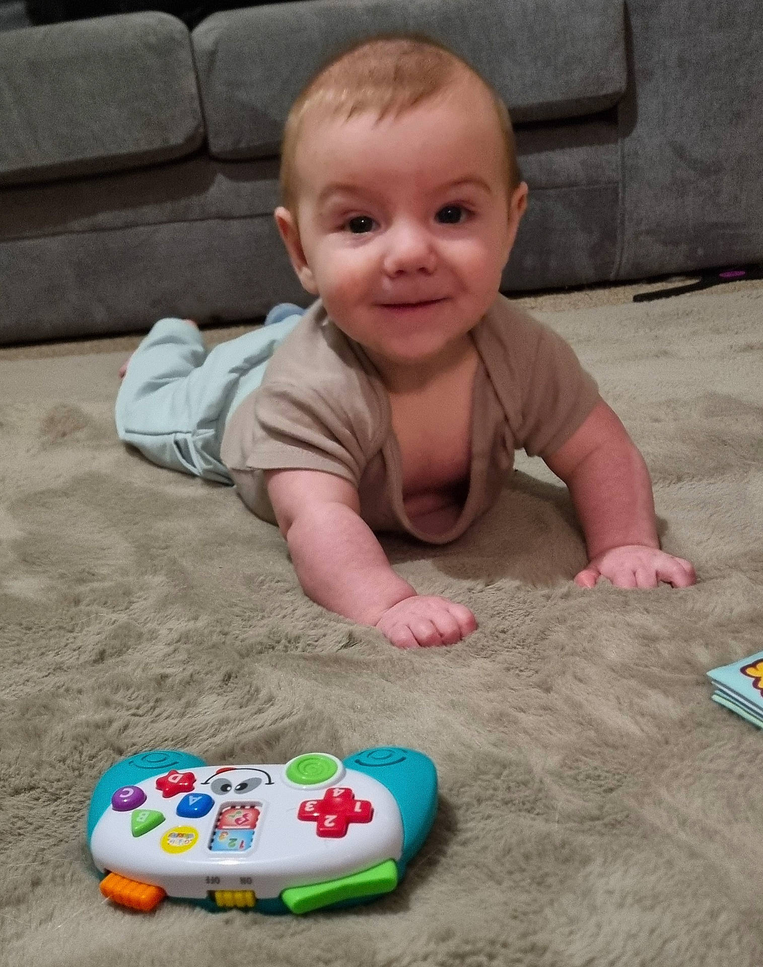 Orlando is registered to the contest to win money with this photo: baby, carpet, child, clothing, couch, cute, eyes, face, floor, furniture, hands, happy, indoor, infant, living_room, person, play, smile, toy, young