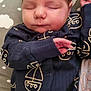 Orlando is registered to the contest to win money with this photo: baby, sleeping, infant, onesie, navy_blue, sailboat_pattern, cushion, cloud_pattern, peaceful, resting, child, cute, soft_lighting, indoor, portrait, hand, face, head, newborn, cozy