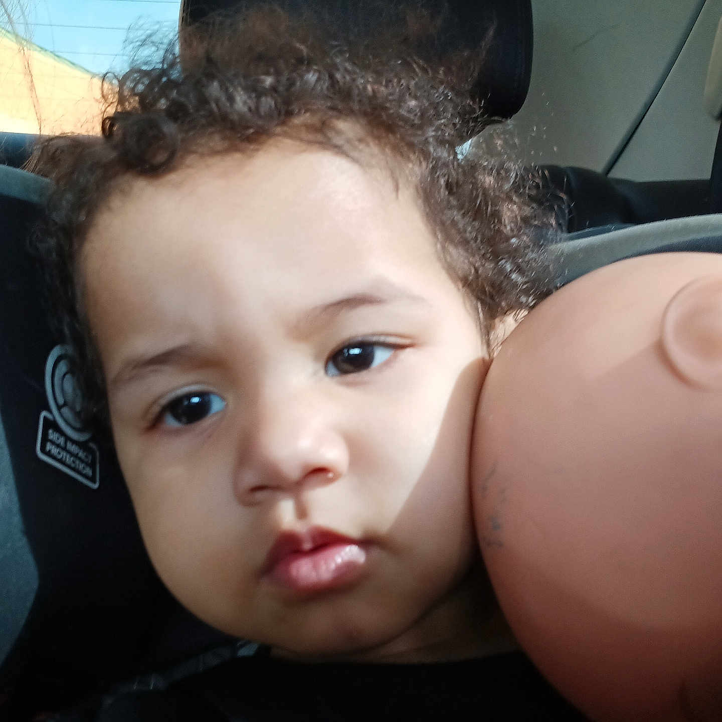Amiracle joined the competition — help win amazing prizes! baby, car_seat, child, closeup, curly_hair, doll, doll_head, expression, face, headrest, indoors, light, person, portrait, seat, shadow, skin, toddler, window, young_child