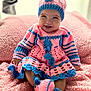 baby, child, smiling, crocheted_clothing, pink, blue, blanket, soft_texture, knitted_hat, knitted_booties, cute, portrait, indoors, happy, sitting, cozy, warm, infant, face, person