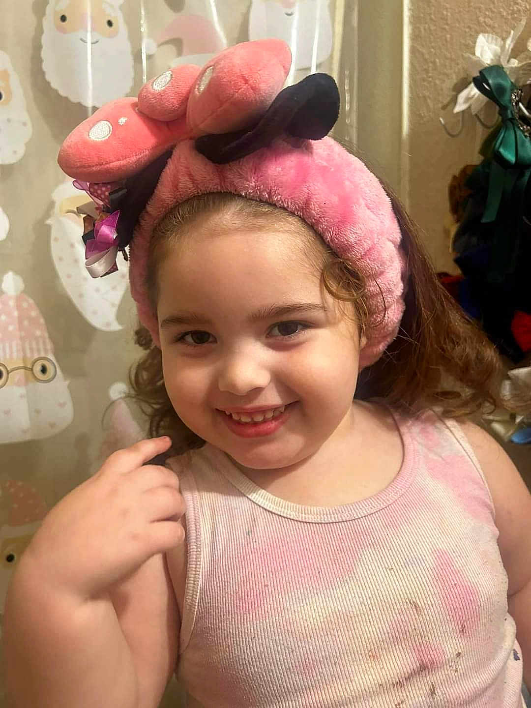 Wynter is registered to the contest to win money with this photo: child, smile, pink_headband, curly_hair, tank_top, indoor, portrait, happy, cute, playful, young_child, furniture, bathroom, decor, person, face, clothing, background, hand, expression