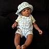baby, child, infant, hat, overalls, blue, white, checkered, sitting, couch, dark_background, curious, cute, indoors, clothing, portrait, feet, hands, face, person