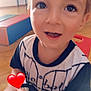 Kenzo participe au concours pour gagner de l'argent avec cette photo : toddler, child, smiling, indoor, toy, vehicle, green, red_heart_emoji, clothing, face, happy, play, wooden_floor, padded_block, black_and_white_shirt, close_up, eyes, hands, young_child, cute