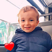 Kenzo a rejoint le concours — aidez-le/la à gagner de superbes lots ! child, smiling, blue_jacket, puffy_jacket, bus_interior, window, heart_emoji, young_boy, portrait, indoor, casual_clothing, happy, face, person, seat, daylight, cute, short_hair, warm_clothing, transportation