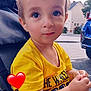 Kenzo participe au concours pour gagner de l'argent avec cette photo : toddler, child, yellow_shirt, stroller, outdoor, daylight, curious, expression, face, hands, seatbelt, car, tree, building, sidewalk, casual_clothing, young_child, cute, person, portrait