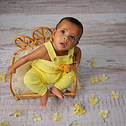 Ethan joined the competition — help win amazing prizes! baby, infant, child, yellow_outfit, teddy_bear, wicker_chair, rattan_basket, cozy_blanket, curious_expression, big_eyes, portrait, studio_shot, props, flower_petals, wooden_floor, bare_feet, button_straps, soft_toys, sitting, cute