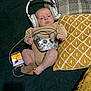Dalton is registered to the contest to win money with this photo: baby, headphones, game_controller, smartphone, couch, pillow, blanket, infant, clothing, socks, technology, indoor, relaxation, child, gamer, screen, hand, foot, face, electronics