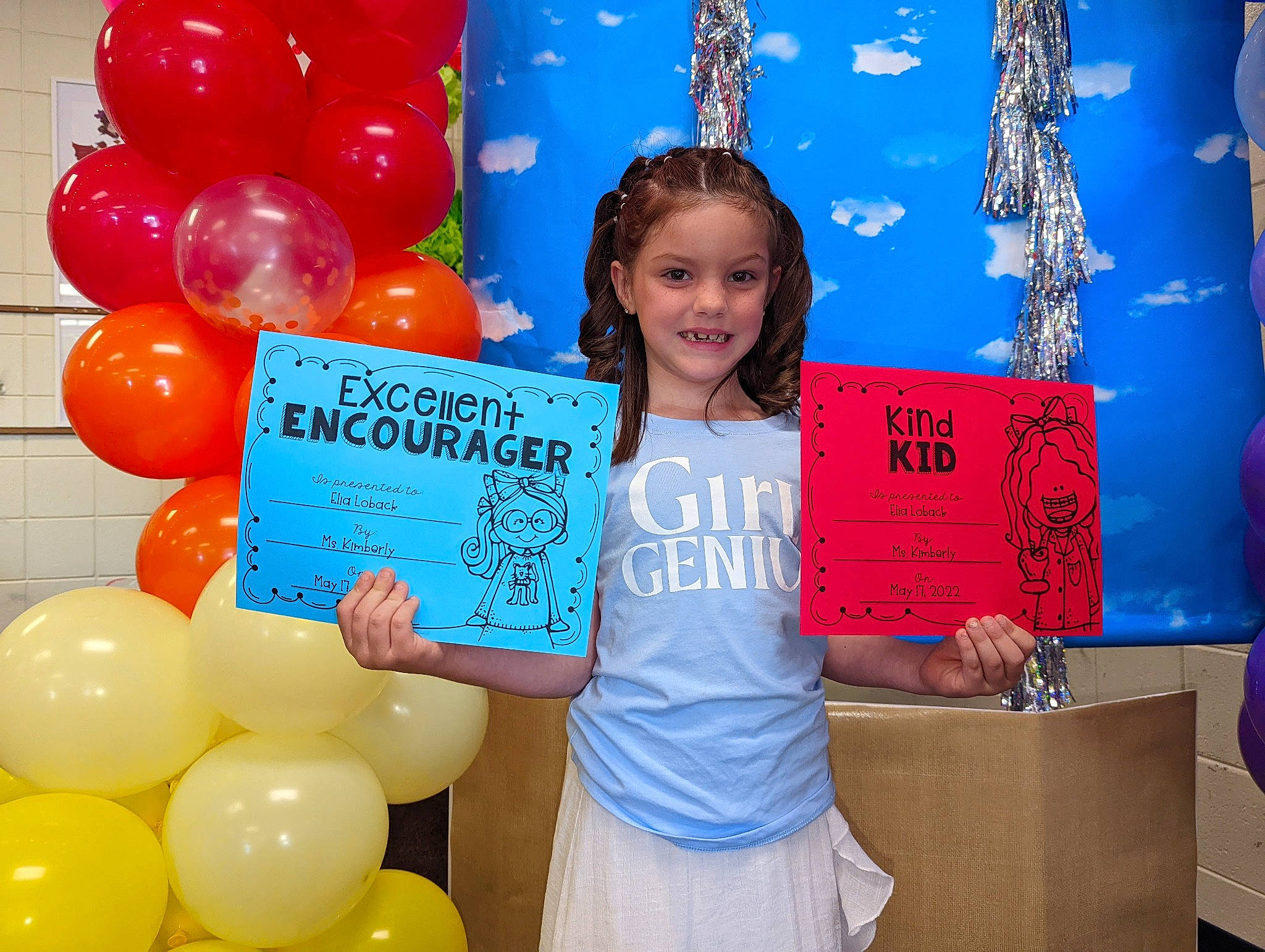 Elia is registered to the contest to win money with this photo: balloon, blue, child, clothing, community, decoration, facial_expression, fashion, fun, happy, human, human_body, joy, organ, person, photograph, red, smile, social_group, t_shirt