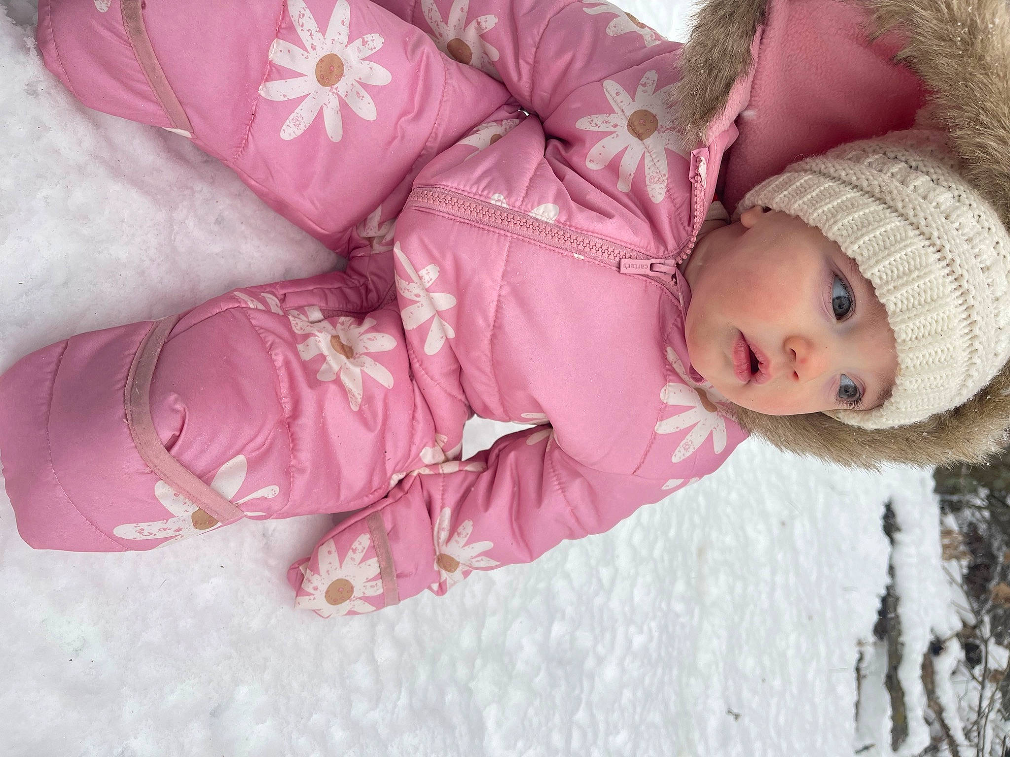Lilah is registered to the contest to win money with this photo: baby, baby_toddler_clothing, beanie, cap, child, comfort, fur, headwear, human_body, knit_cap, linens, magenta, pattern, person, petal, pink, sleeve, snow, toddler, tree