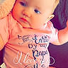 baby, infant, onesie, pink_clothing, blanket, couch, face, child, cute, portrait, indoor, soft_lighting, expression, skin, head, person, young, sitting, love_message, text_overlay
