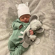 Zayvian is registered to the contest to win money with this photo: newborn, baby, sleeping, plush_toy, elephant, hat, onesie, blanket, cozy, infant, cute, soft, peaceful, child, clothing, indoors, resting, hand, footed_pajamas, adorable
