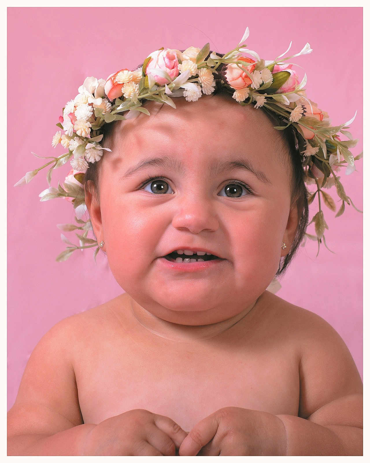 Crystal is registered to the contest to win money with this photo: baby, child, flower_crown, pink_background, portrait, smiling, cute, skin, face, hands, earrings, infant, close_up, adorable, happy, looking_up, head_accessory, expression, soft_lighting, studio_photo