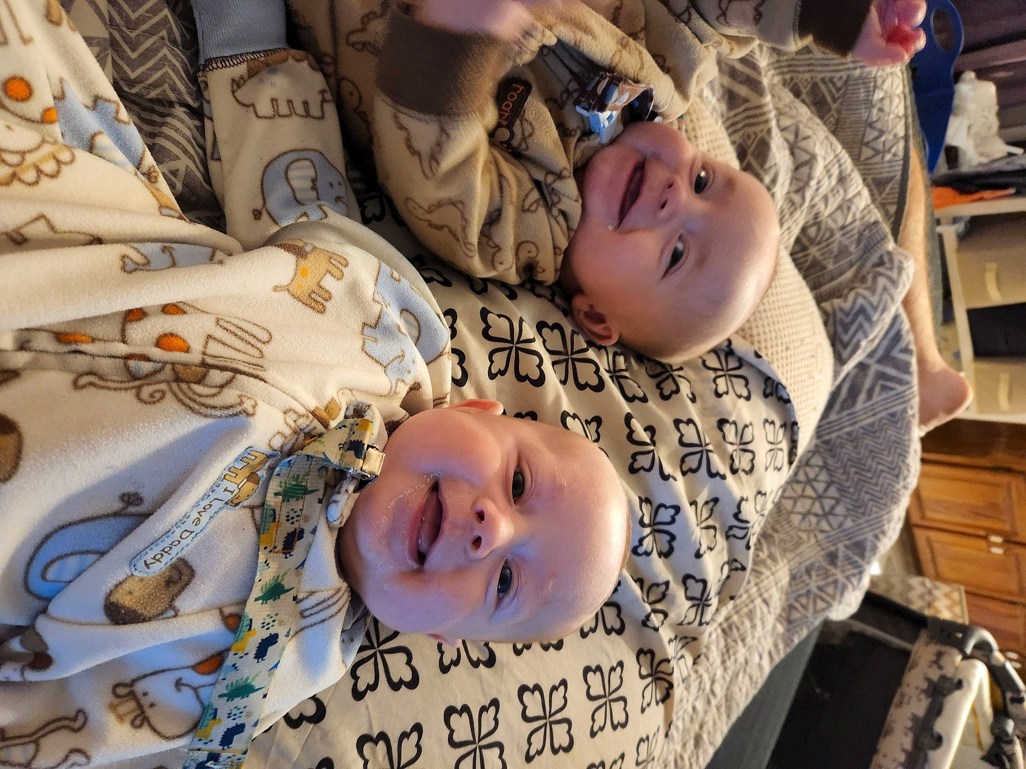 Caleb is registered to the contest to win money with this photo: baby, baby_products, baby_toddler_clothing, cheek, child, comfort, facial_expression, fun, happy, linens, people, person, product, room, shelf, skin, sleeve, smile, textile, toddler