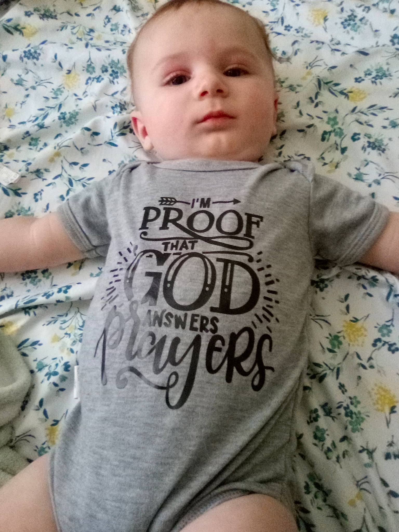 Billy is registered to the contest to win money with this photo: baby, baby_toddler_clothing, cheek, child, chin, comfort, eye, face, font, grey, happy, head, linens, mouth, neck, pattern, person, skin, sleeve, t_shirt