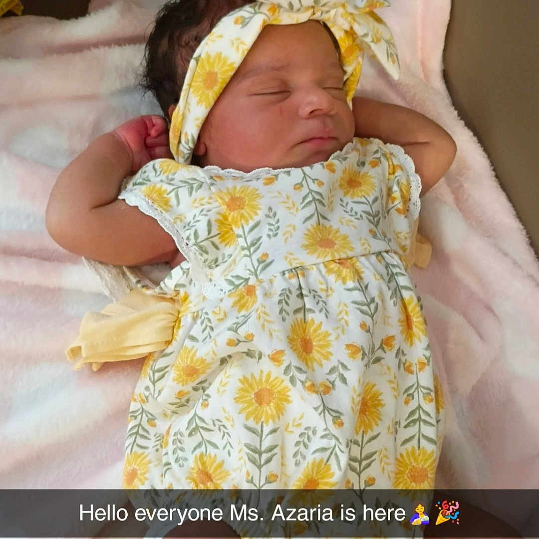 Azaria joined the competition — help win amazing prizes! newborn, baby, sleeping, infant, portrait, floral_dress, headband, bow, sunflower, pink_blanket, lying_down, indoors, nursery, baby_clothing, peaceful, face, arms, legs, snapchat_overlay, announcement