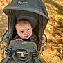 baby, child, face, carrier, outdoor, nature, autumn, leaves, smile, person, head, straps, forest, sunlight, happy, baby_carrier, clothing, young_child, seated, daylight