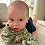 Joe is registered to the contest to win money with this photo: baby, child, blanket, tummy, face, eyes, skin, infant, person, indoors, soft_texture, clothing, head, expression, curious, closeup, portrait, focus, couch, resting