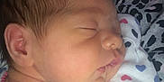 Camila is registered to the contest to win money with this photo: newborn, baby, sleeping, infant, face, onesie, heart_pattern, leopard_print, clothing, closeup, peaceful, cute, soft, child, portrait, skin, head, ear, person, resting