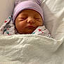 Camila is registered to the contest to win money with this photo: newborn, baby, sleeping, blanket, hat, swaddled, infant, bed, cute, peaceful, soft, white, heart_pattern, child, face, closed_eyes, cozy, portrait, resting, indoors