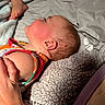 newborn, baby, sleeping, infant, face, profile, blanket, bed, pajamas, clothing, foot, hand, parent, indoors, portrait, resting, cozy, soft_texture, nursery, candid