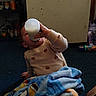 blanket, bottle, carpet, child, colorful, cozy, cup, daily_life, drinking, face, hand, home, indoor, pajamas, playroom, portrait, shelf, sitting, toddler, toy