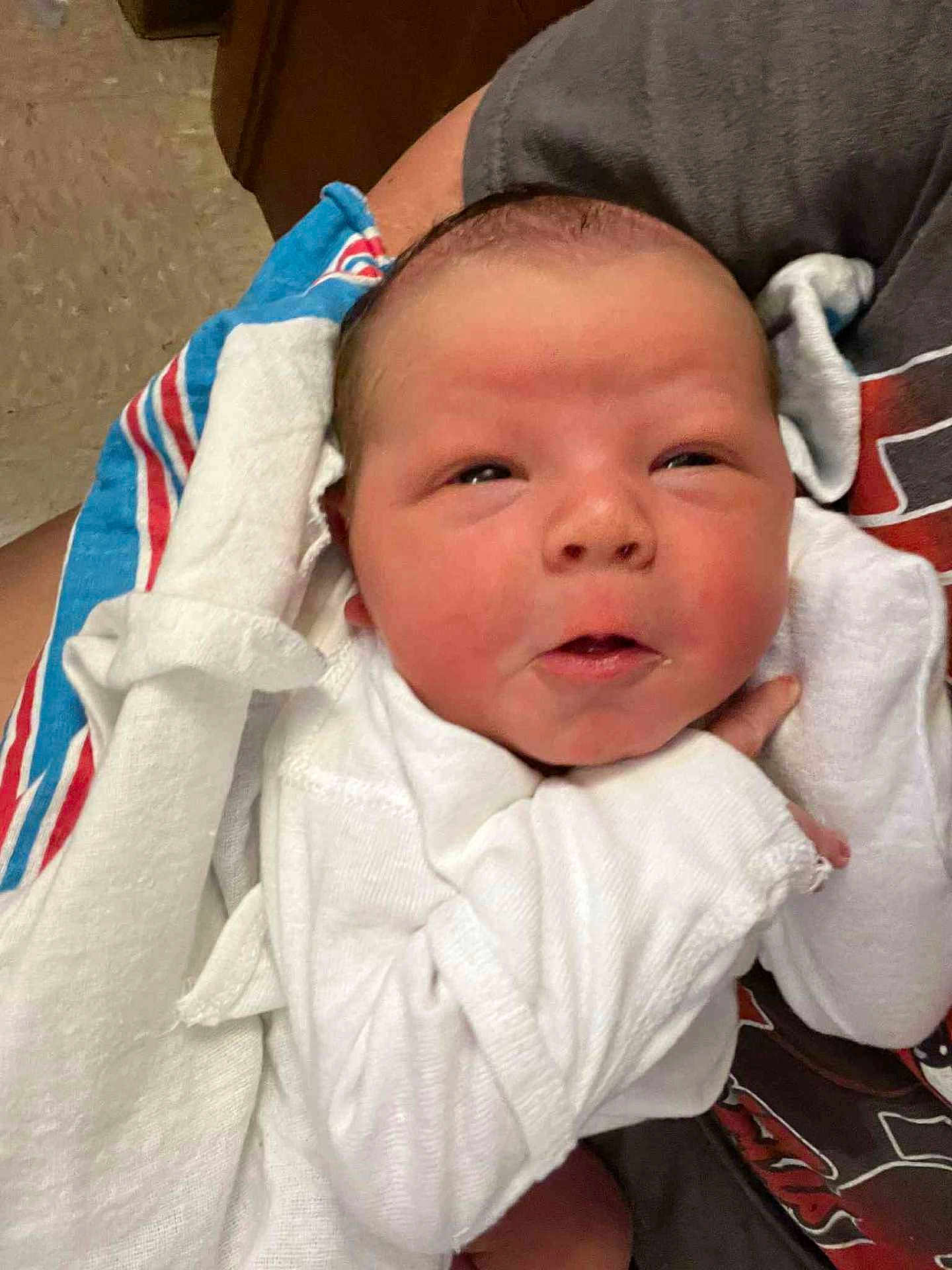 Liam is registered to the contest to win money with this photo: newborn, baby, infant, white_clothing, blanket, person, hand, face, expression, cradling, closeup, indoor, human, skin, head, toddler, cute, sleepwear, comfort, resting