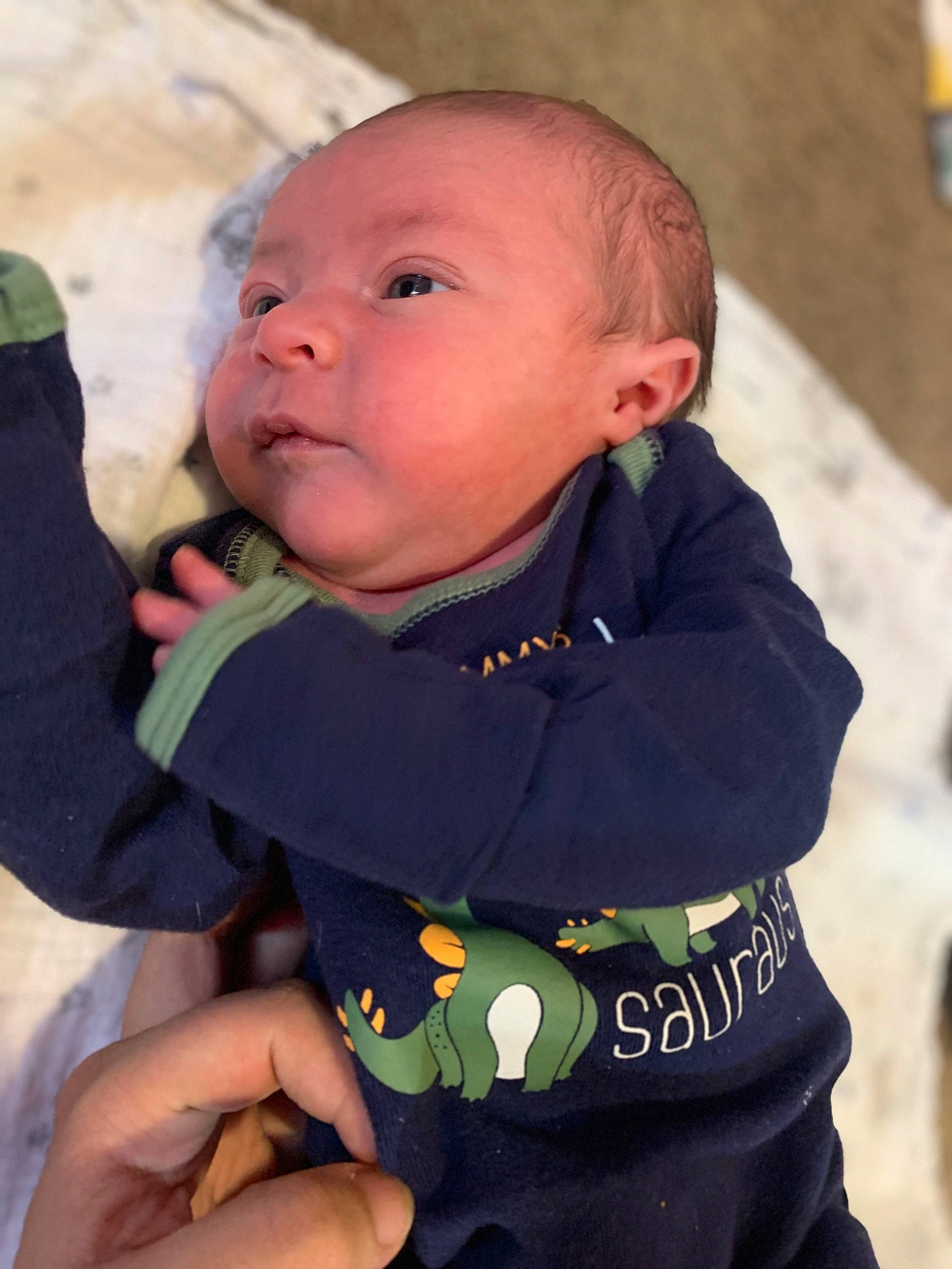 Izaiah is registered to the contest to win money with this photo: baby, baby_toddler_clothing, cheek, chin, finger, fun, gesture, hand, happy, head, iris, nail, nose, person, product, sitting, skin, sleeve, t_shirt, thumb