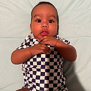 Ivan joined the competition — help win amazing prizes! baby, infant, child, checkered_clothing, hands, face, eyes, mouth, skin, lying_down, soft_surface, blue_background, cute, portrait, one_person, indoors, young_child, expression, curious, casual