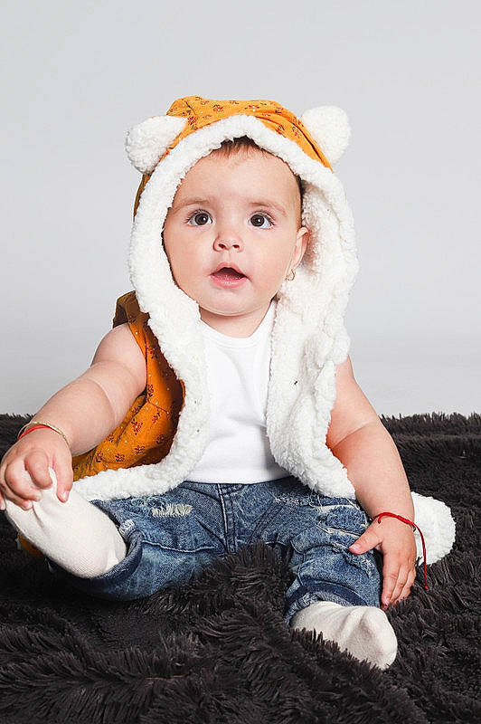 Cataleya is registered to the contest to win money with this photo: baby, baby_toddler_clothing, beanie, cap, cheek, child, costume_accessory, costume_hat, eyelash, fashion_accessory, flash_photography, fur, grass, happy, headband, headpiece, headwear, person, portrait_photography, sitting