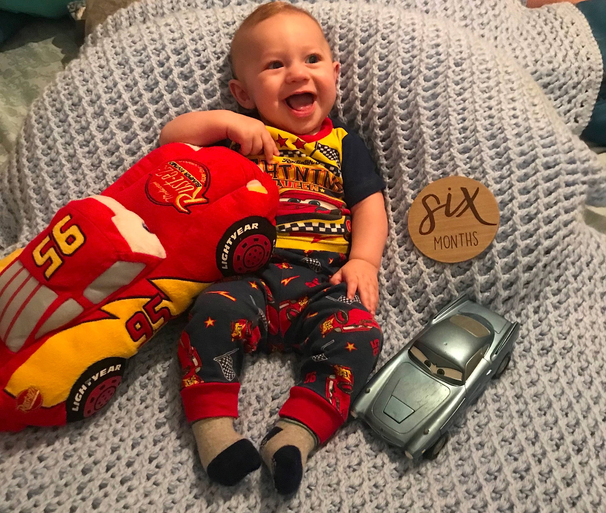 Jesse James is registered to the contest to win money with this photo: baby, baby_products, baby_toddler_clothing, carmine, child, comfort, couch, flooring, gadget, happy, linens, person, personal_protective_equipment, sitting, sleeve, smile, sports_gear, t_shirt, textile, toddler