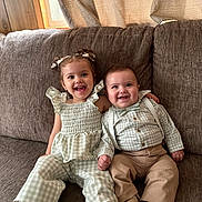 Zeliylah joined the competition — help win amazing prizes! toddler, baby, child, smiling, couch, indoors, curtains, window, clothing, suspenders, pigtails, bows, shoes, pink_sneakers, happy, portrait, sitting, face, cute, family